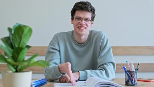 Young Adult Explains Lesson While Sitting at Desk
