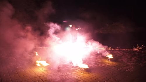 Fire Dancer Performing at Night on Brick Surface