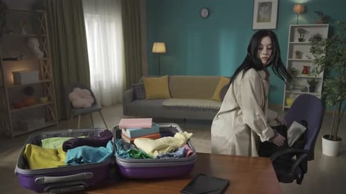 Video of a Teenager Teen Young Woman Packing Her Belongings in a Suitcase and Backpack She Looks at