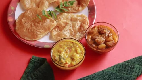 rotation Chole Bhature or Chick pea curry and Fried Puri served in terracotta crockery over red bac