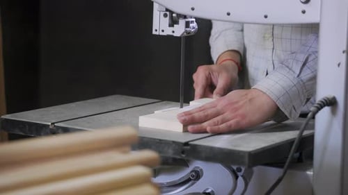 A man works with wood in a workshop. Working with wooden blanks. A man drills holes in wooden blanks