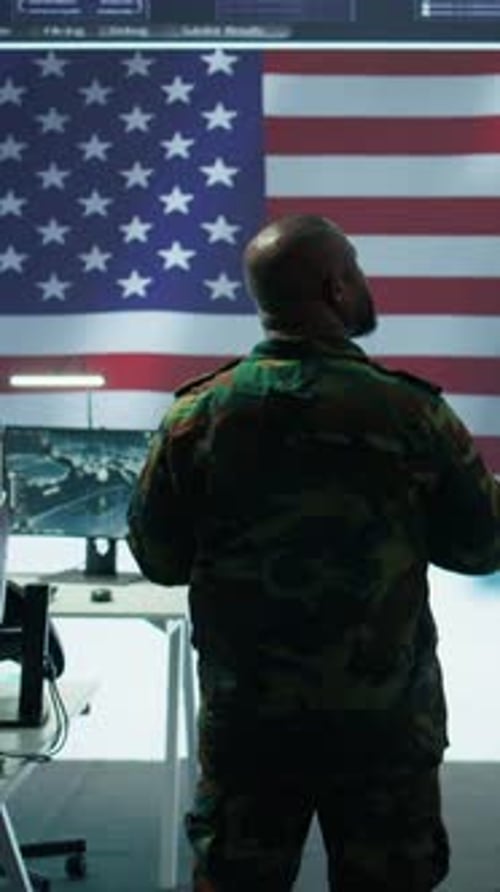 Soldier Stands Before Screen Showing American Flag