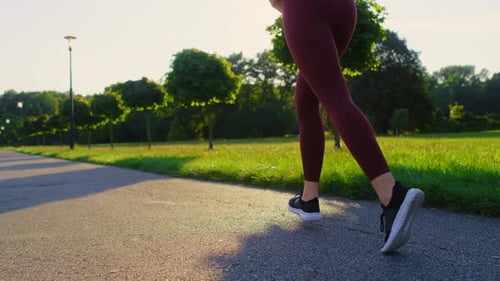 Close up of unrecognizable woman jogging in the park