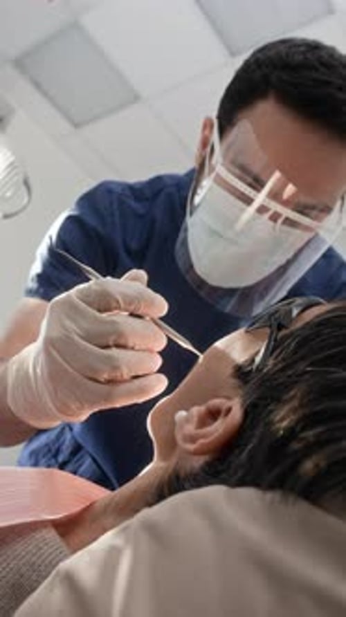 Dentist Using Dental Tools to Inspect Patient Mouth During Procedure