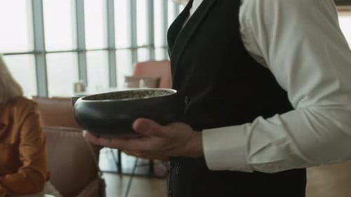 Waiter Serving Delicious Food to Female Guests in Luxury Restaurant
