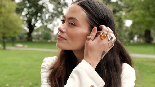 Mujer feliz en un parque sonriendo.