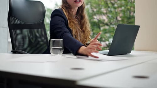 in a Modern Office with a Large Window a Beautiful Worker in a Blue Shirt with a Laptop Talk on a