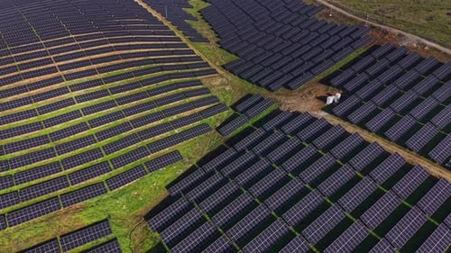 Solar panels cover large field in rural area during daytime