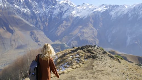mulher viajante está caminhando ao longo de um caminho de montanha