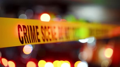 A Bright Yellow Crime Scene Tape Across an Urban Environment Marking a Restricted Area for