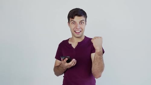 Man Celebrates Success on Smartphone
