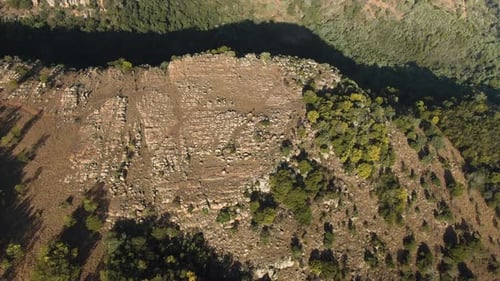 Aerial footage flying over a cliff edge of a gorge.