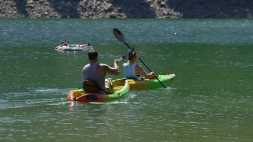 Couple enjoying a kayaking adventure on a serene lake in summer