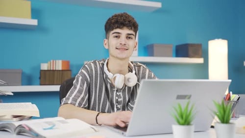 Young Adult Typing on Laptop at Desk Indoors