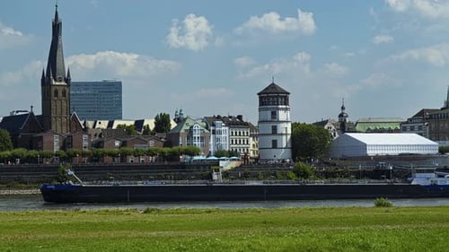 Container vessel moves along the river Rhine passing through Dusseldorf
