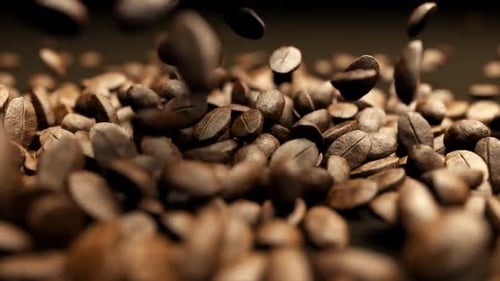 Falling Roasted Coffee Beans on Dark Surface
