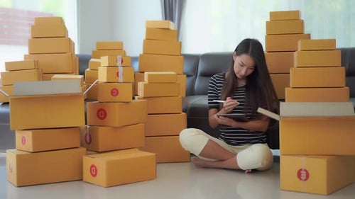 Woman with Tablet Surrounded by Shipping Boxes