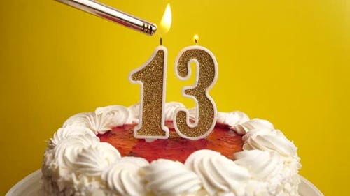 13. A candle in the form of the number 13, inserted into the holiday cake, is lit. Celebrating a bir