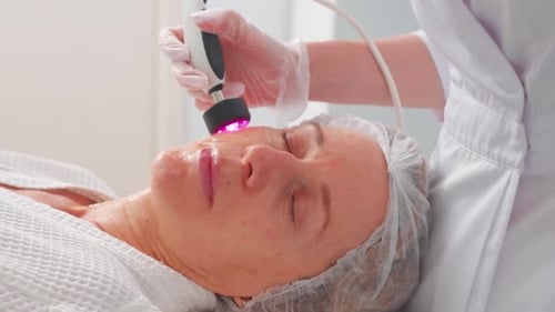 Woman Getting Fractional Microneedle RF Face Lifting Procedure in Beauty Salon