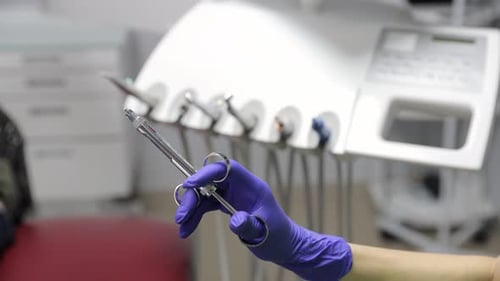 Gloved Hand Holding Medical Syringe in Dental Office
