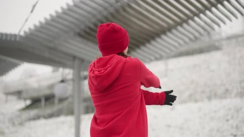 Back View of Woman Stretching Arms During Outdoor Winter Workout