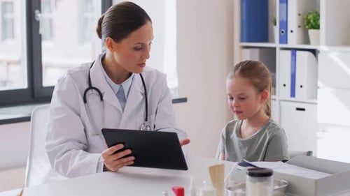 Doctor Shows Tablet to Young Patient in Office