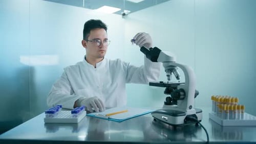 Scientist Examining Test Tubes in Bright Lab