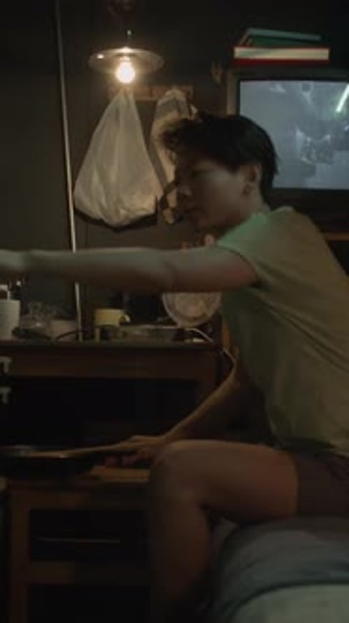 Asian Capsule Flat Resident Preparing to Eat Dinner Alone in Evening