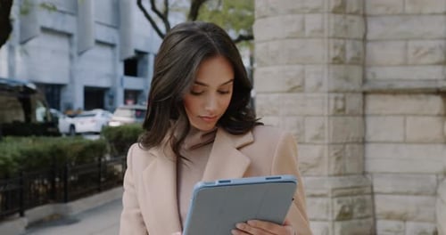 A Closeup Shot of a Young Businesswoman on a City Street Focused While Working on Her Tablet Slow