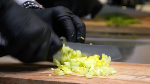 Der Koch schneidet Sellerie in dünne Scheiben