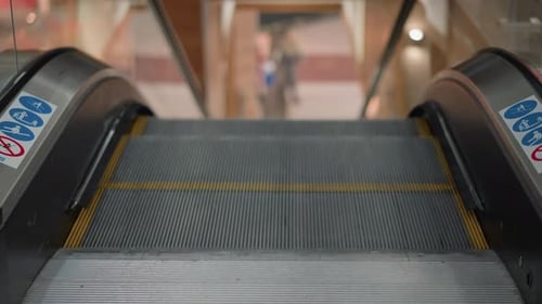Entrance View of Moving Walkway Ascending with Blurred Shoppers