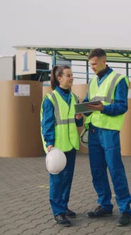 Engineers in a Carton Packaging Factory are Standing Near Unloading Platform Workers at a Cardboard