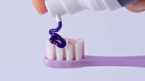 Pouring a whitening purple toothpaste.