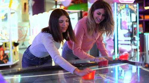 Friends Playing Air Hockey in Arcade