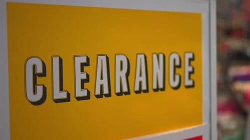 Clearance sale bright yellow and white sign in small local business department store shop in mall du