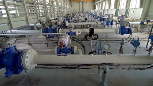 Rows of Industrial Pipelines Equipped with Valves, Gauges, and Actuators Run Through a Clean, Well-L