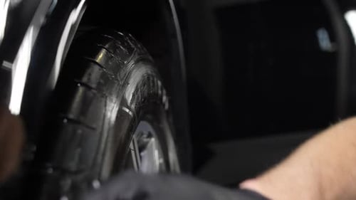Close Up A Worker Waxes Tires with a Sponge Tire Wax