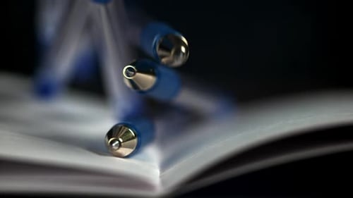 Pens Fall on an Open School Notebook Filmed on a Highspeed Camera at 1000 Fps