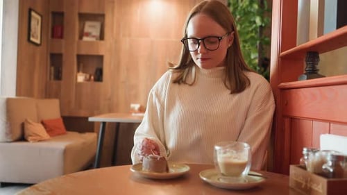 Young Student Eating Dessert with Coffee in Cozy Wooden Cafe Interior During Break
