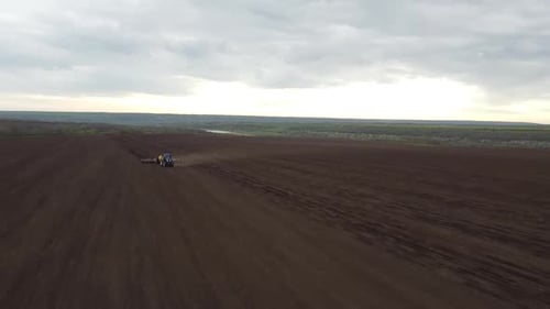 Blue tractor OA working on the field in Ukraine