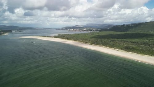 Vista aérea de la playa de Camarido con océano sereno, Portugal.