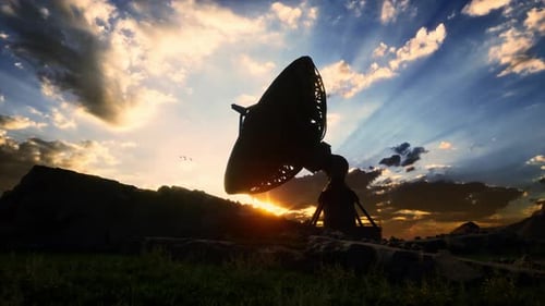 Rotating Satellite Dish Against Sunset Sky