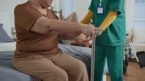 Caregiver Assists Senior with Walking Cane