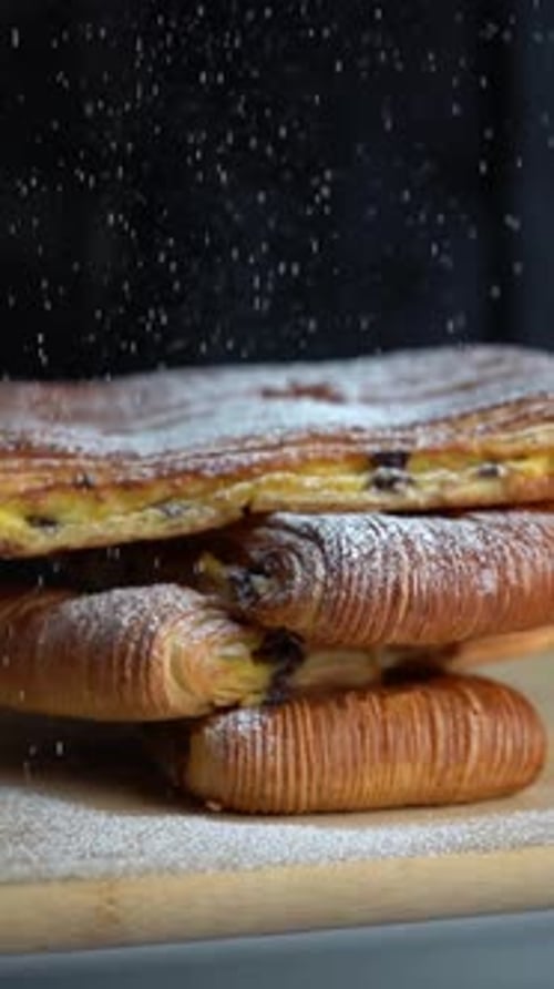 A chief adds salt to croissant pastry filled with cream and close up shot, insert shot