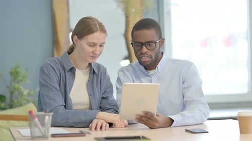 Two People Use Tablet at Table