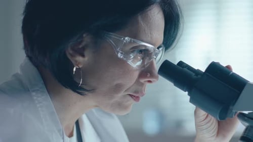 Woman Scientist Working with Microscope in Laboratory