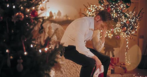 Pensive Young Man by Christmas Tree