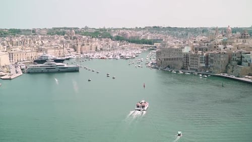 Boat heading towards Malta's Three Cities harbor next to Valletta