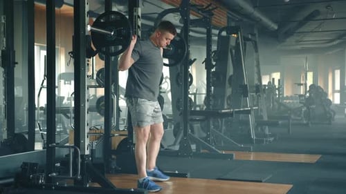 Process of Performing Barbell Squats By Fit Sportsman in Wellequipped Gym