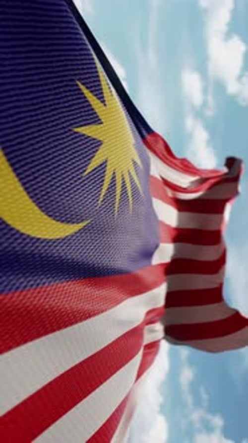 Realistic Malaysian Flag Waving Against Blue Sky